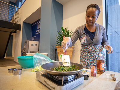 Fiona Lewis, a dietitian in the Department of Preventive Medicine, cooks kale and squash dishes at the Office of Wellbeing's fair at the Clinton Billing Office.